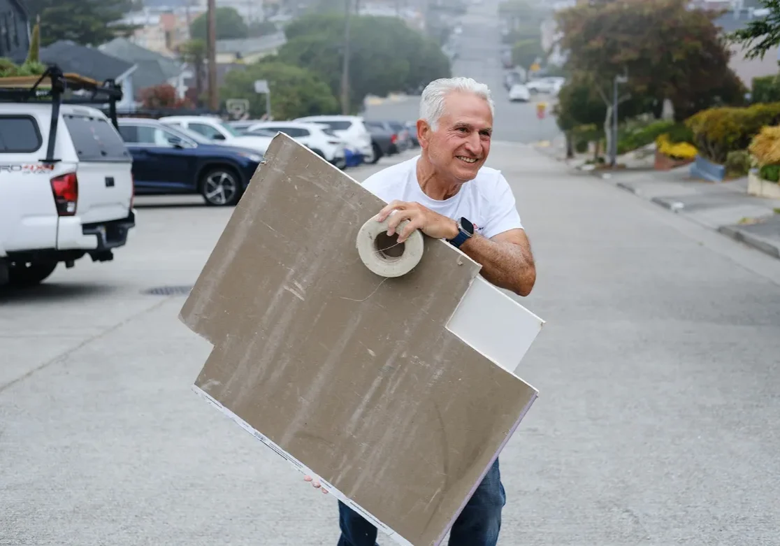 Sabri repairing and painting the exterior of a home as part of a San Francisco renovation project